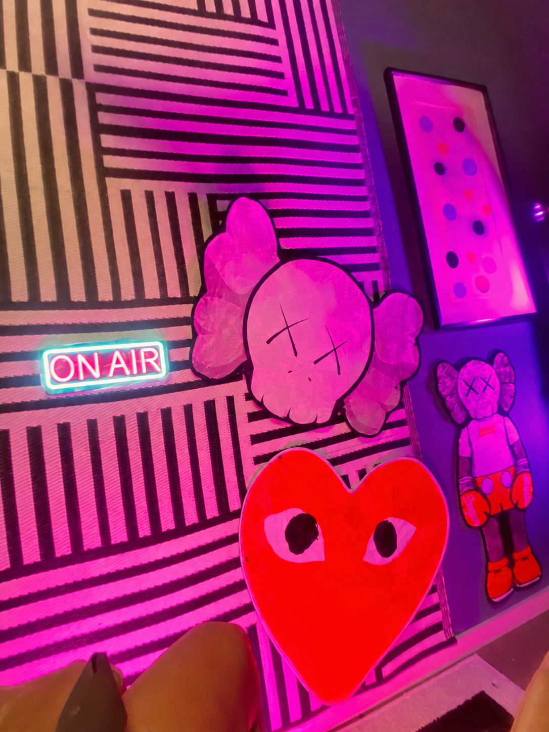 Black Coffee graphic set wall with pink lighting, an On Air sign and illustrated artwork